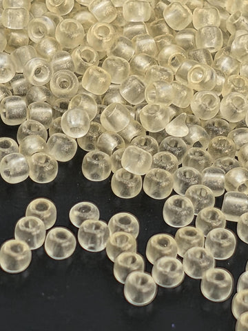 a close-up view of numerous transparent, clear beads scattered on a dark background.