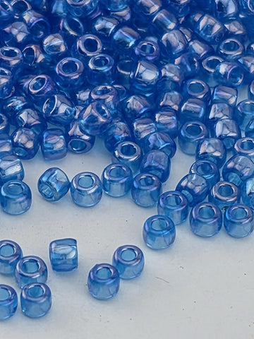 a collection of small, clear blue beads scattered on a white surface.