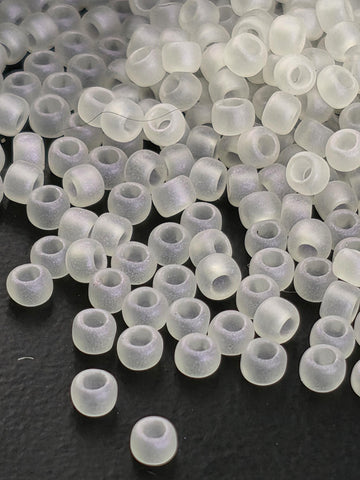 a collection of small, clear beads scattered on a dark surface.