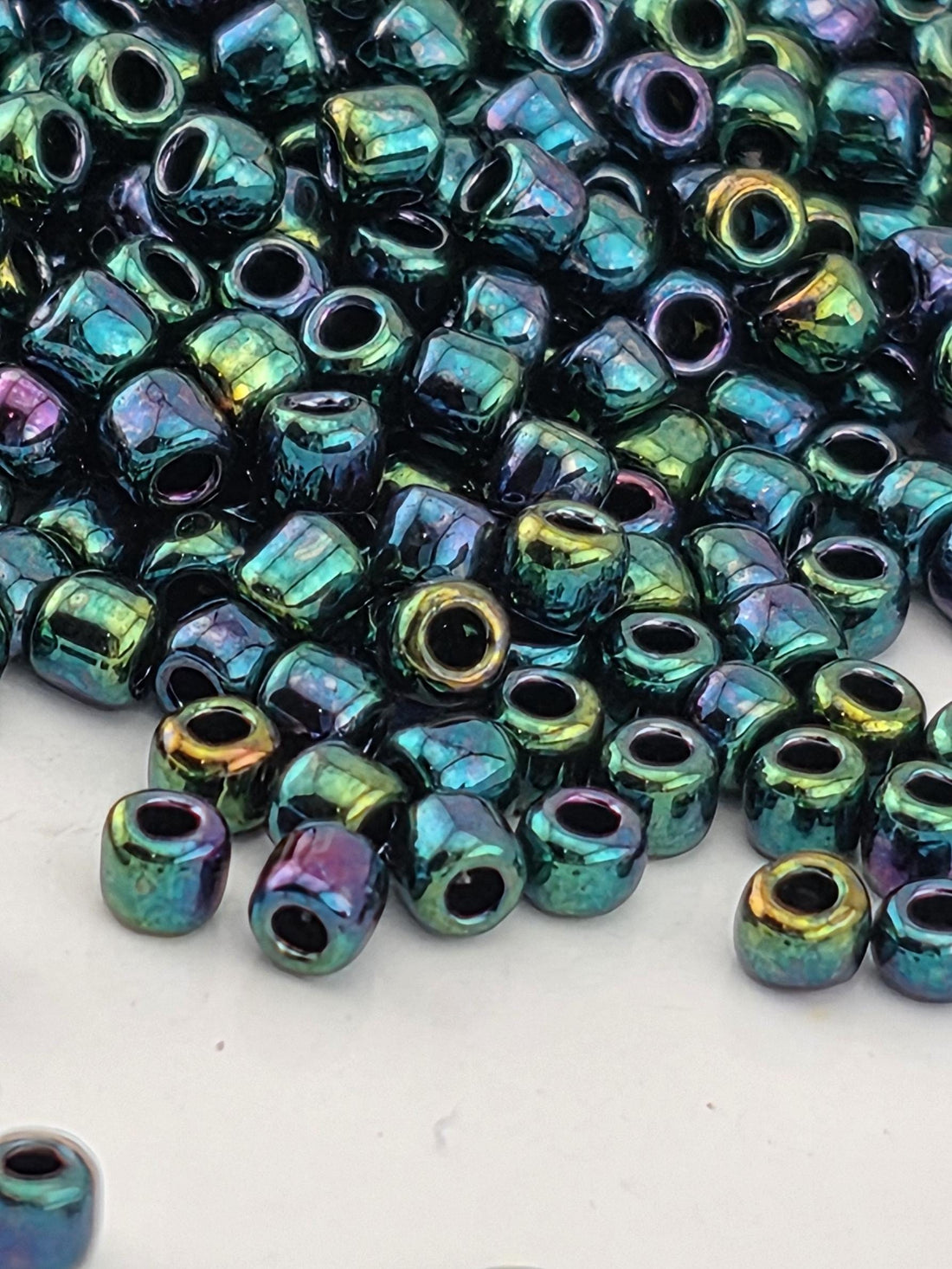 a close-up view of a pile of multicolored glass beads, with various shades of blue, green, and purple.