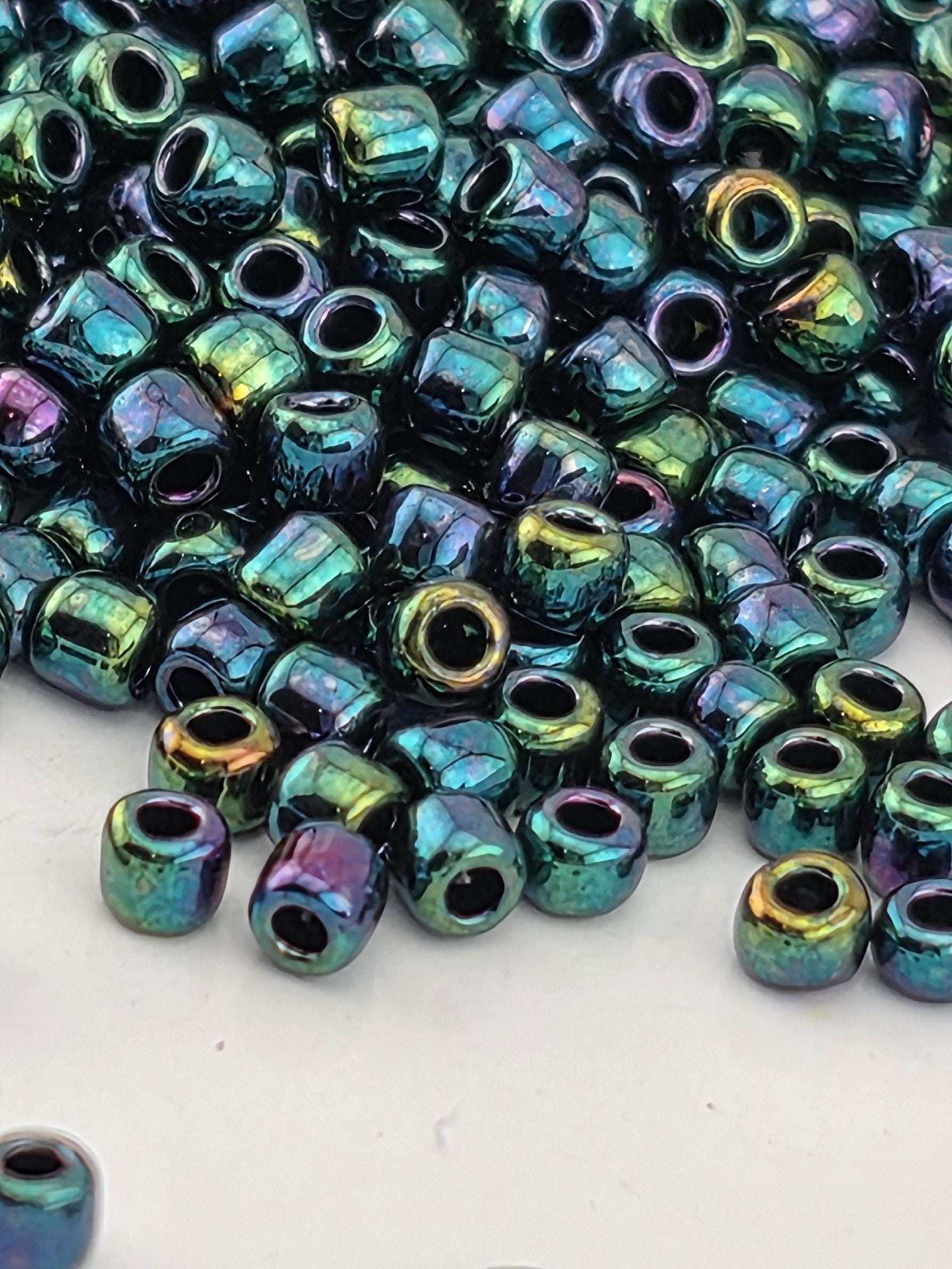a close-up view of a pile of multicolored glass beads, with various shades of blue, green, and purple.
