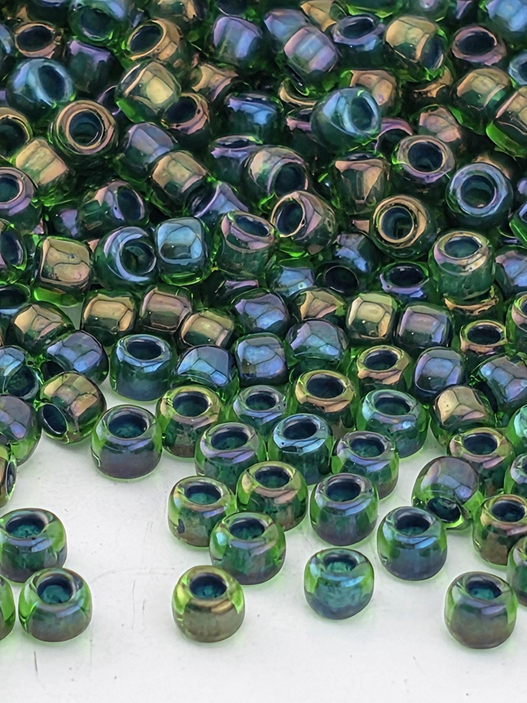 a close-up view of numerous green and blue glass beads scattered across a surface.