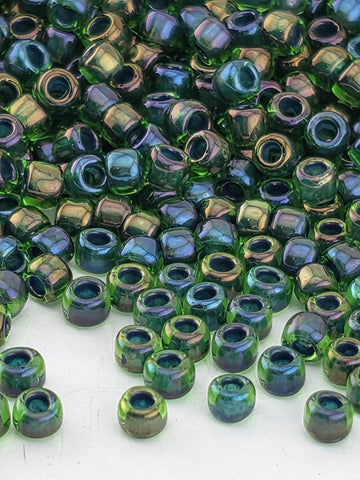 a close-up view of numerous green and blue glass beads scattered across a surface.