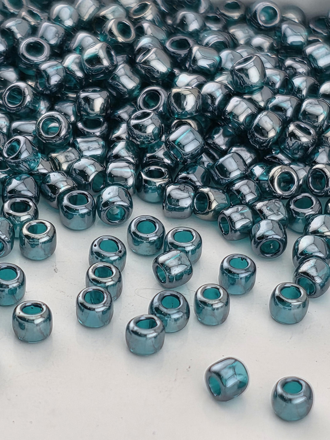 a collection of small, round beads in various shades of blue, scattered across a white surface.