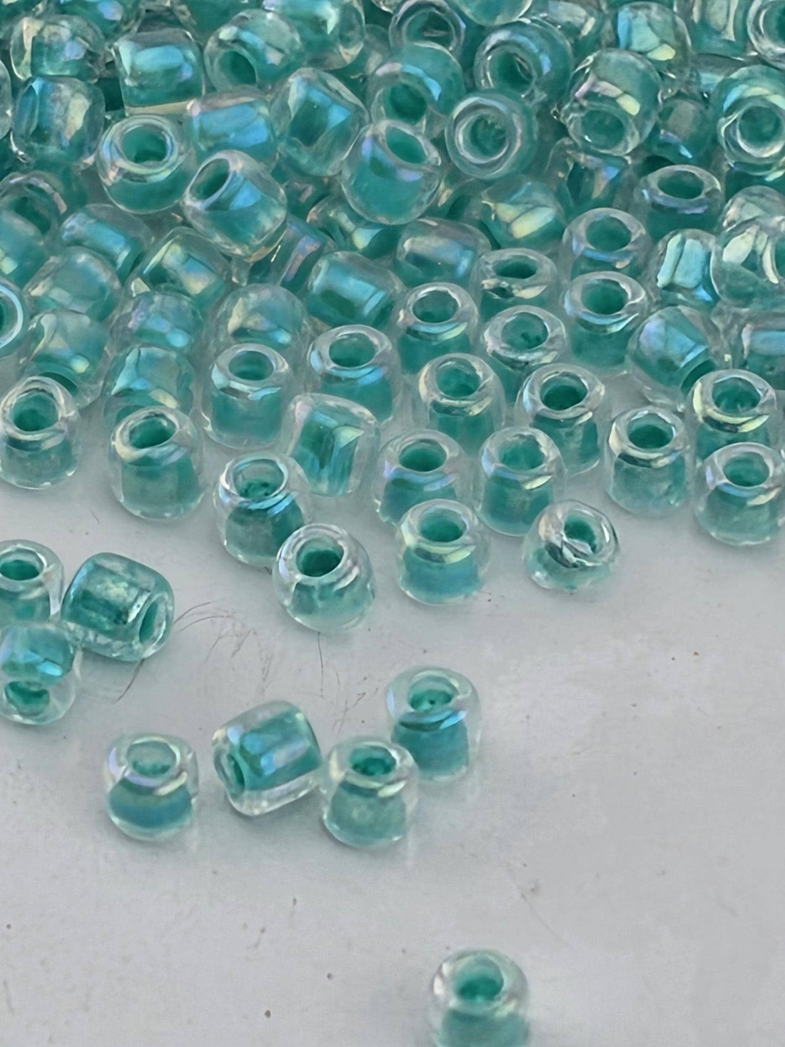 a collection of small, clear beads scattered on a white surface.