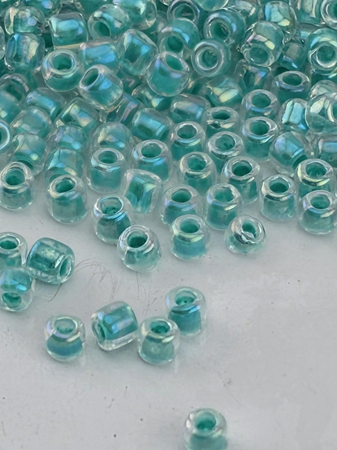 a collection of small, clear beads scattered on a white surface.
