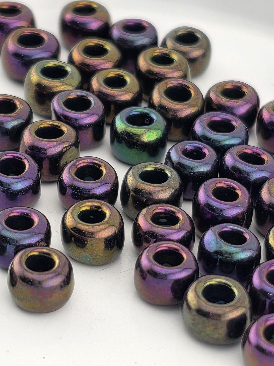 a collection of multicolored beads, including purple, green, and gold, arranged in a visually appealing manner.