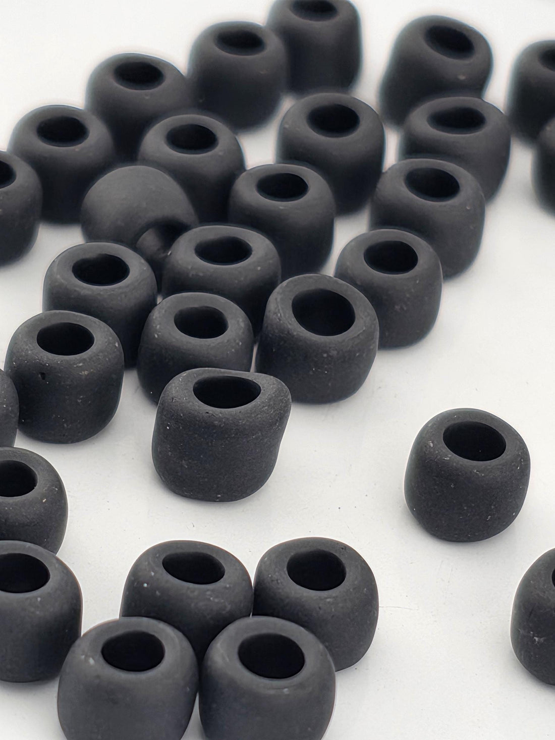 a collection of black, round objects arranged in a scattered pattern on a white background.