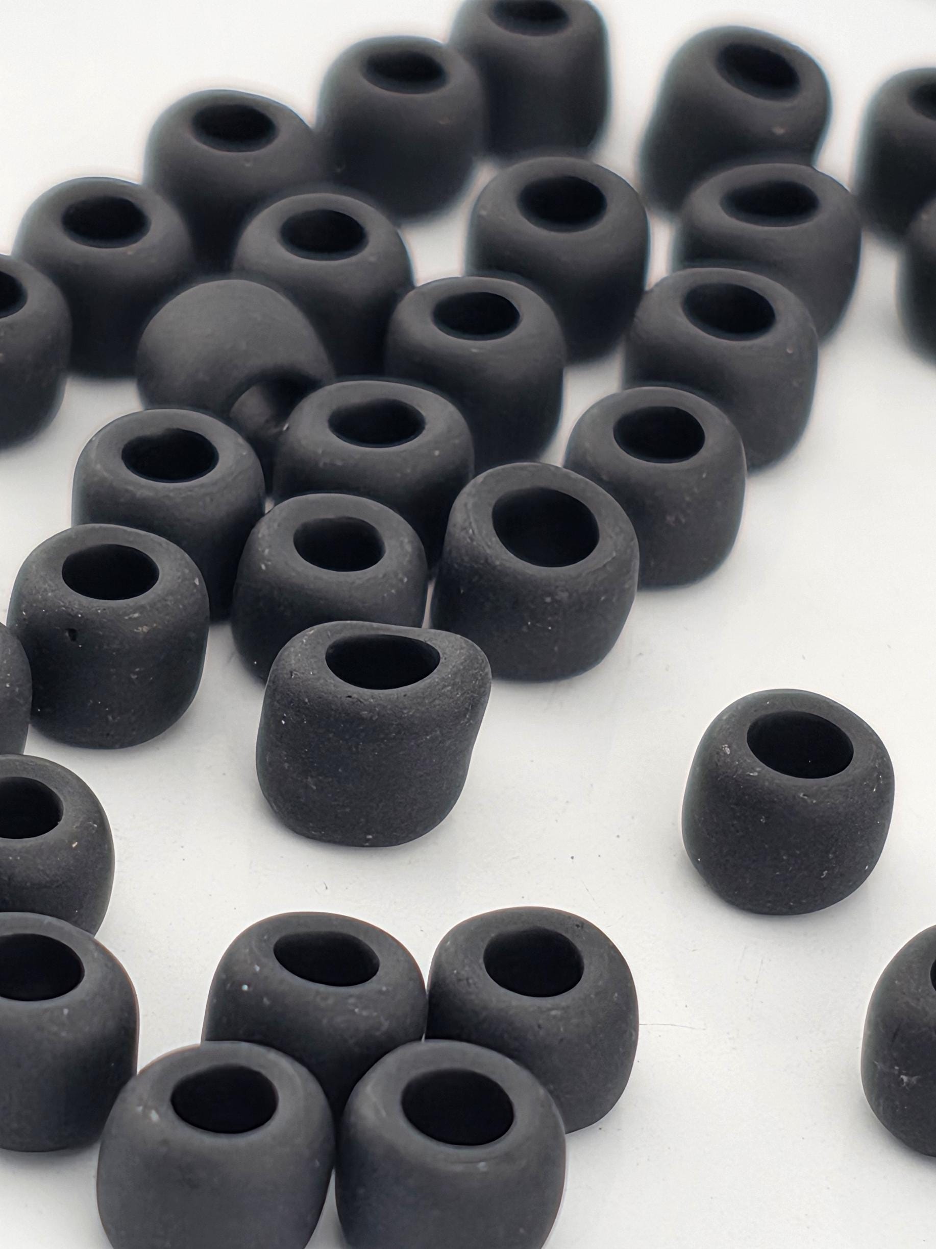 a collection of black, round objects arranged in a scattered pattern on a white background.