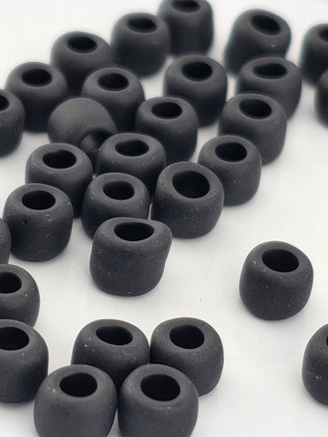 a collection of black, round objects arranged in a scattered pattern on a white background.