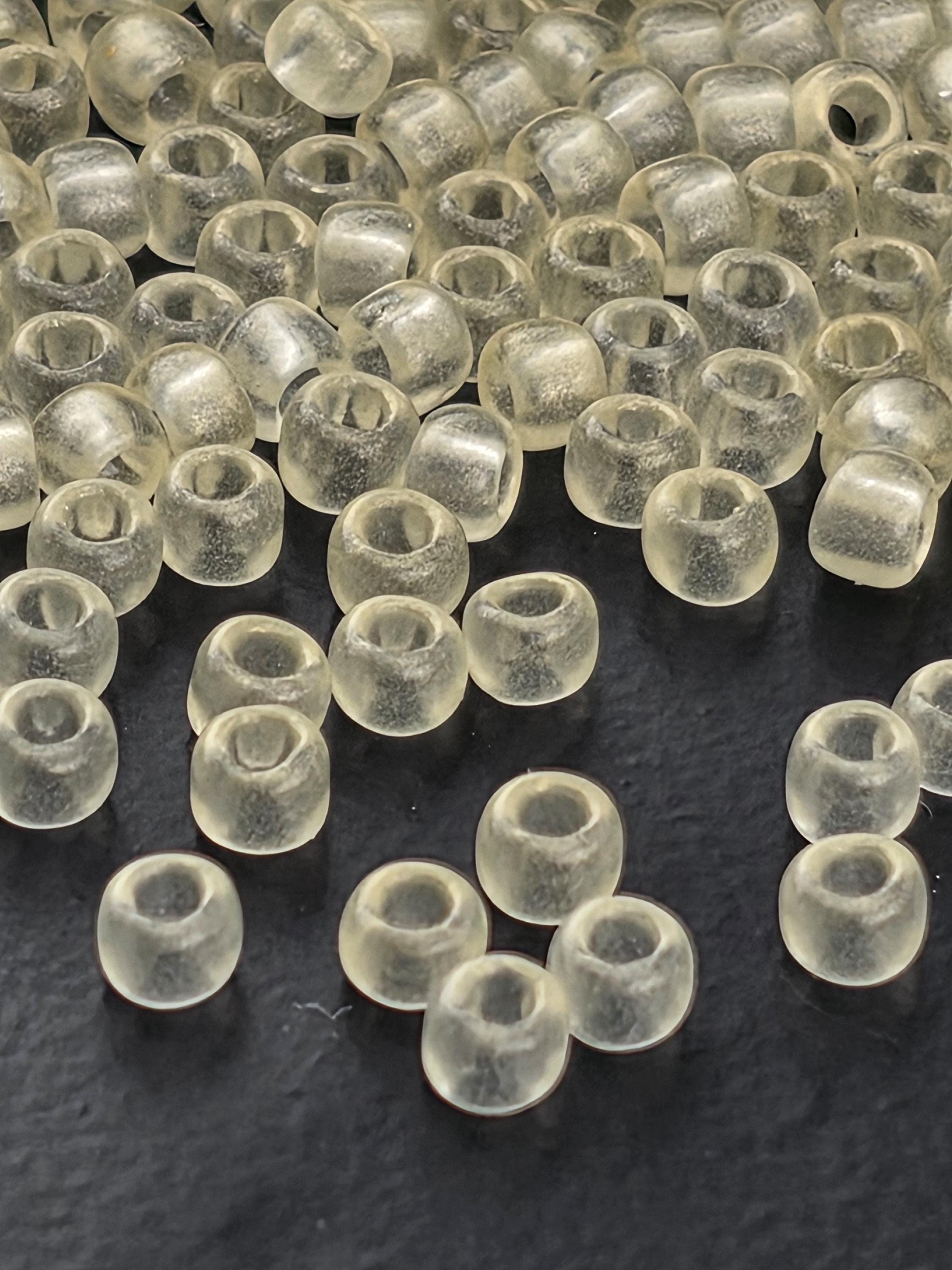 a collection of clear, transparent beads scattered on a dark surface.
