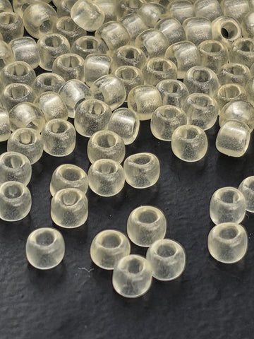 a collection of clear, transparent beads scattered on a dark surface.