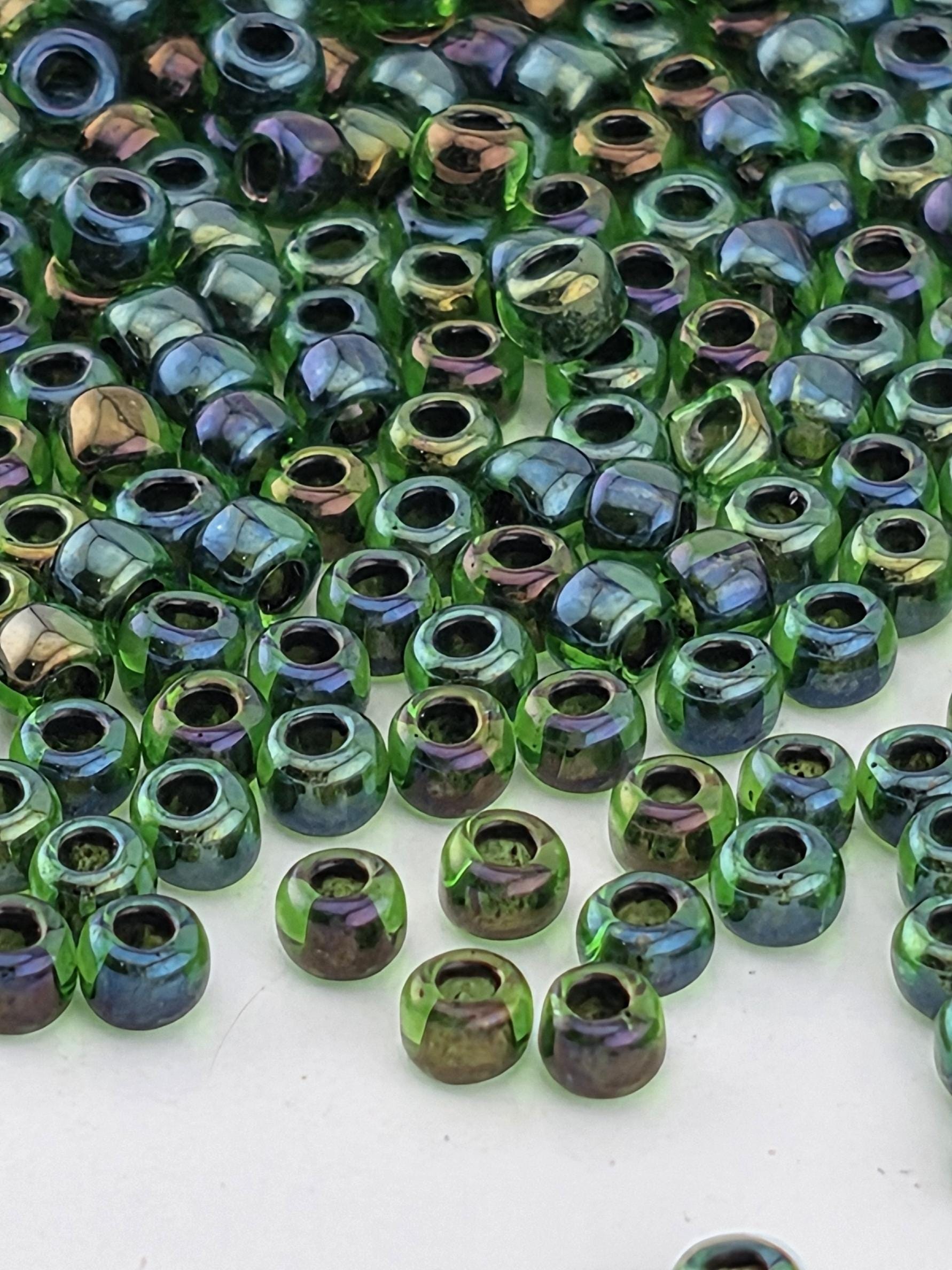a close-up view of numerous green and purple glass beads scattered across a surface.