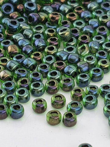 a close-up view of numerous green and purple glass beads scattered across a surface.