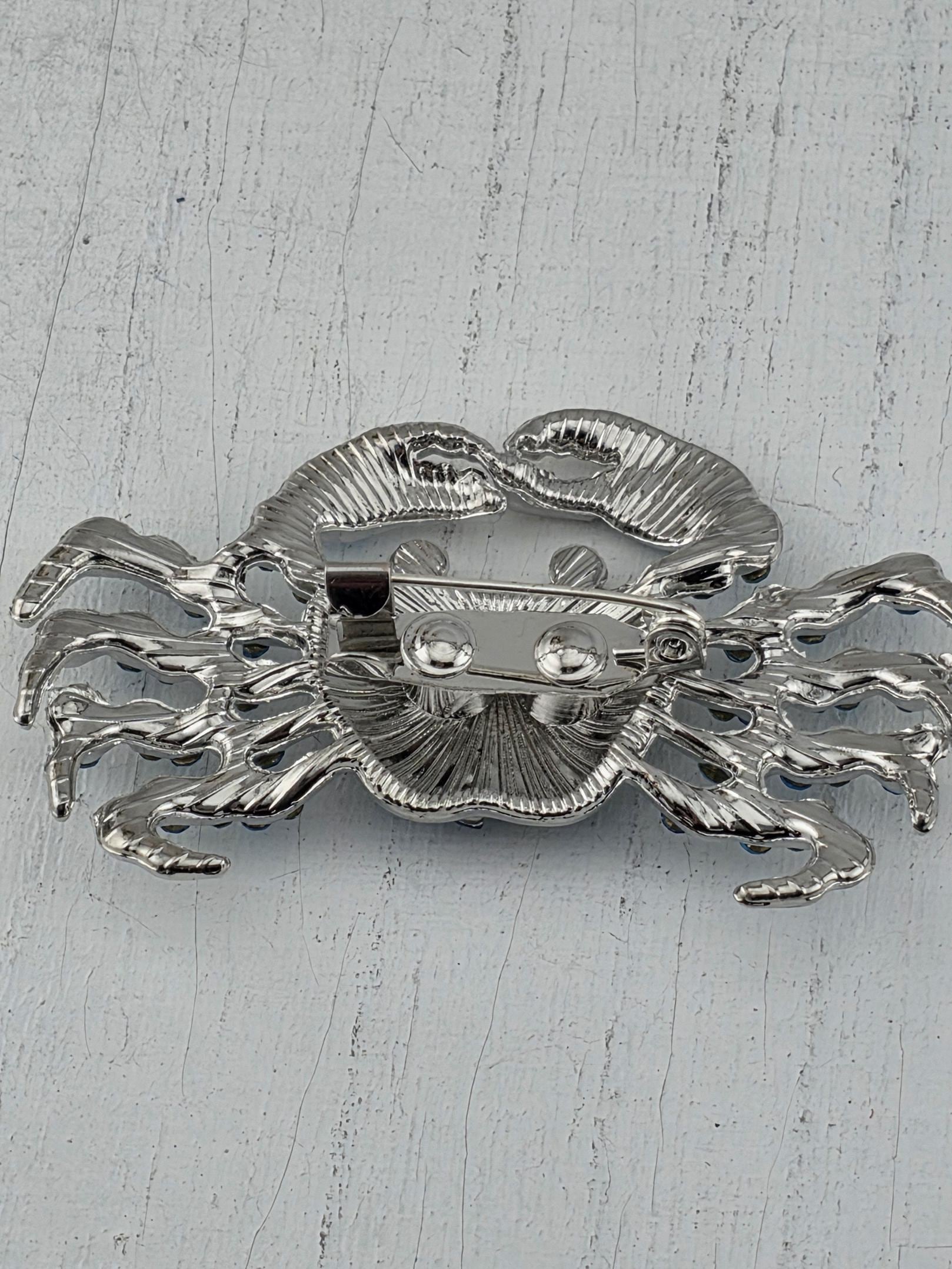 A silver metal object with a unique, intricate design resembling a crab or sea creature.