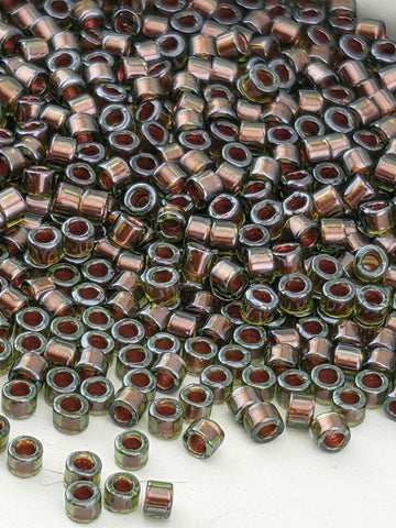 a large pile of small, round beads in various colors, including shades of brown and green.