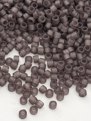 a large pile of small, round, grey beads or objects scattered on a white surface.