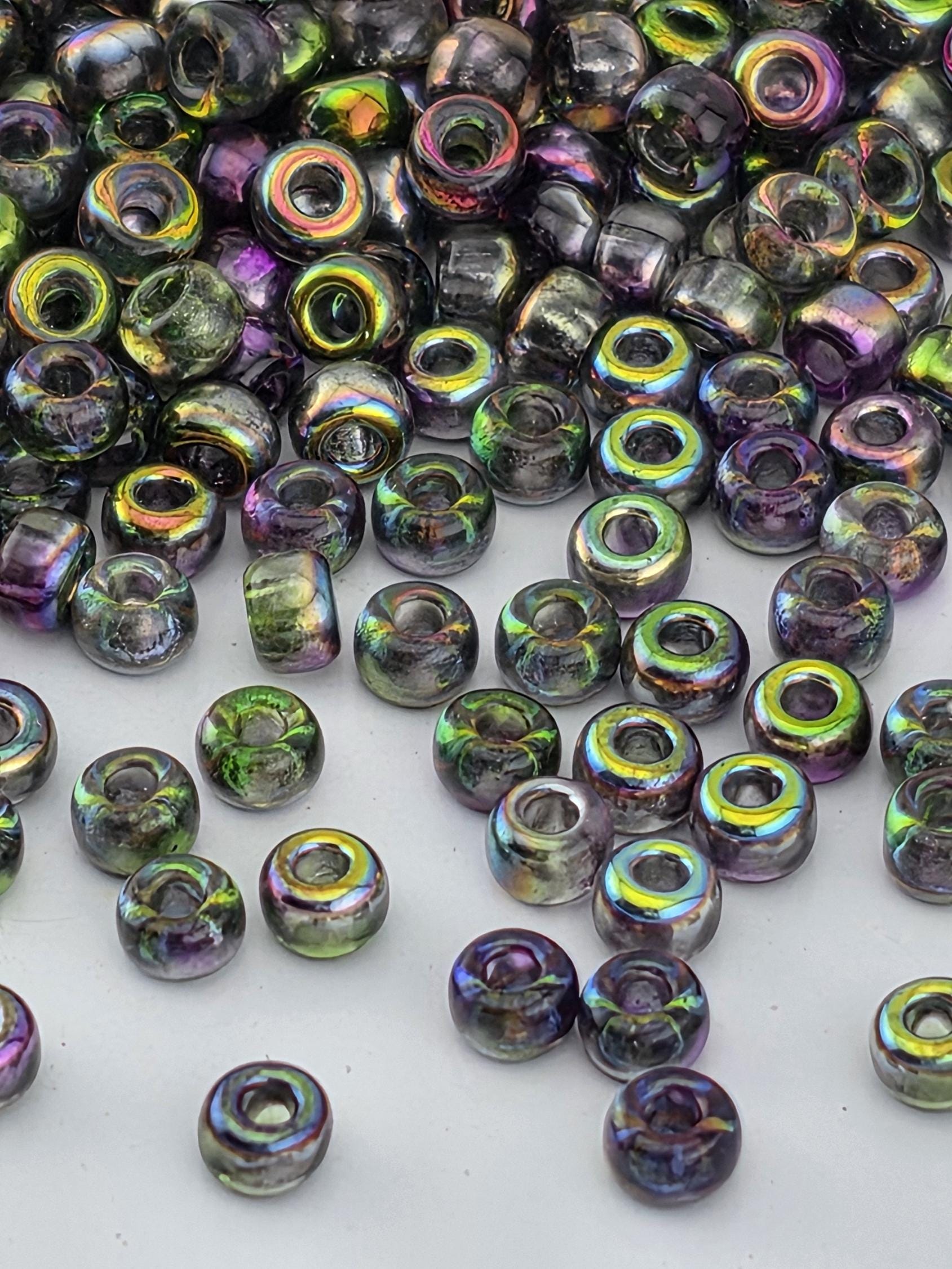 a collection of multicolored glass beads scattered on a white surface.