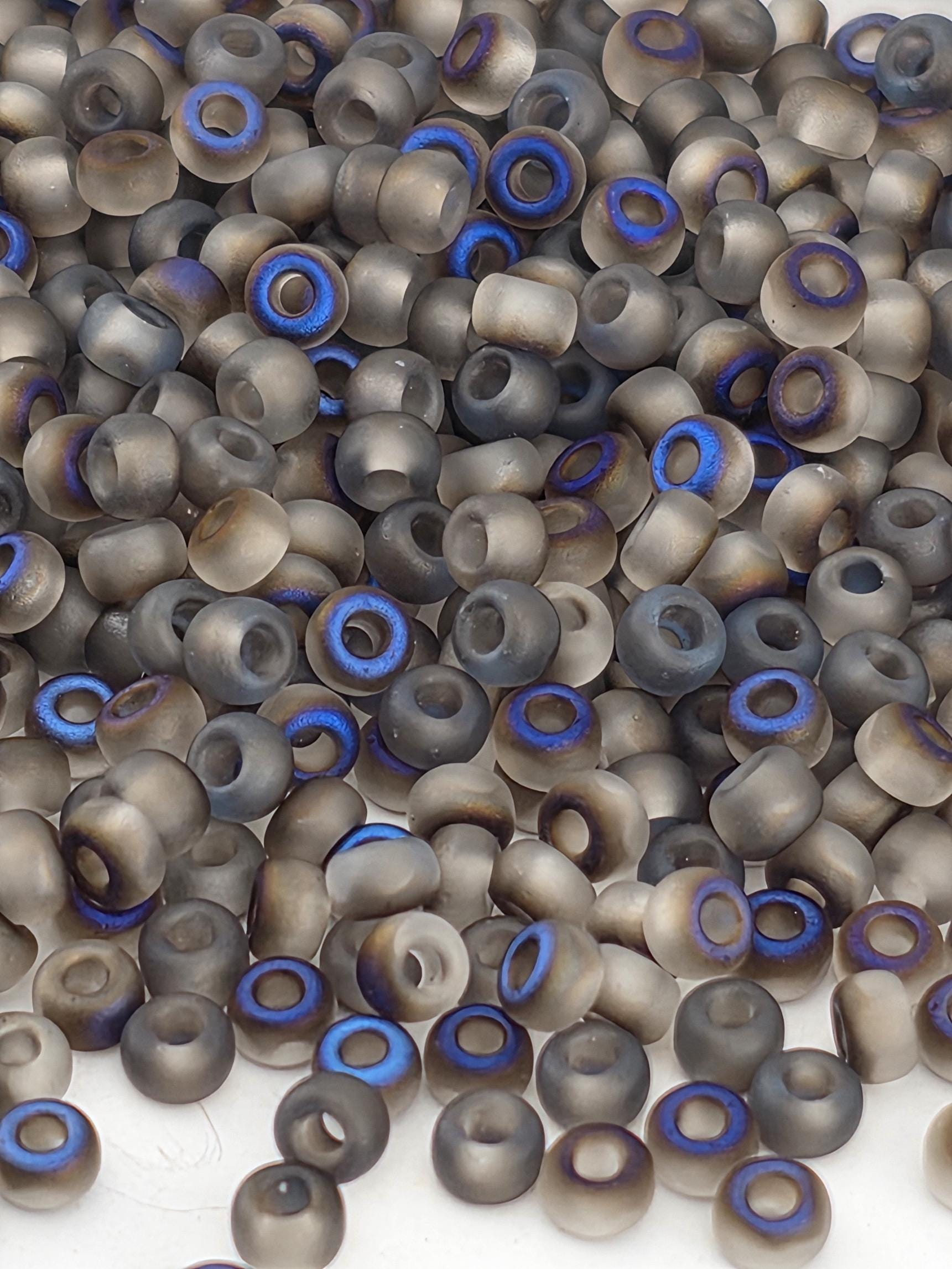 a close-up view of numerous small, round beads with a mix of gray and blue colors. The beads appear to be made of a material that resembles glass or plastic, and they are scattered across a surface.