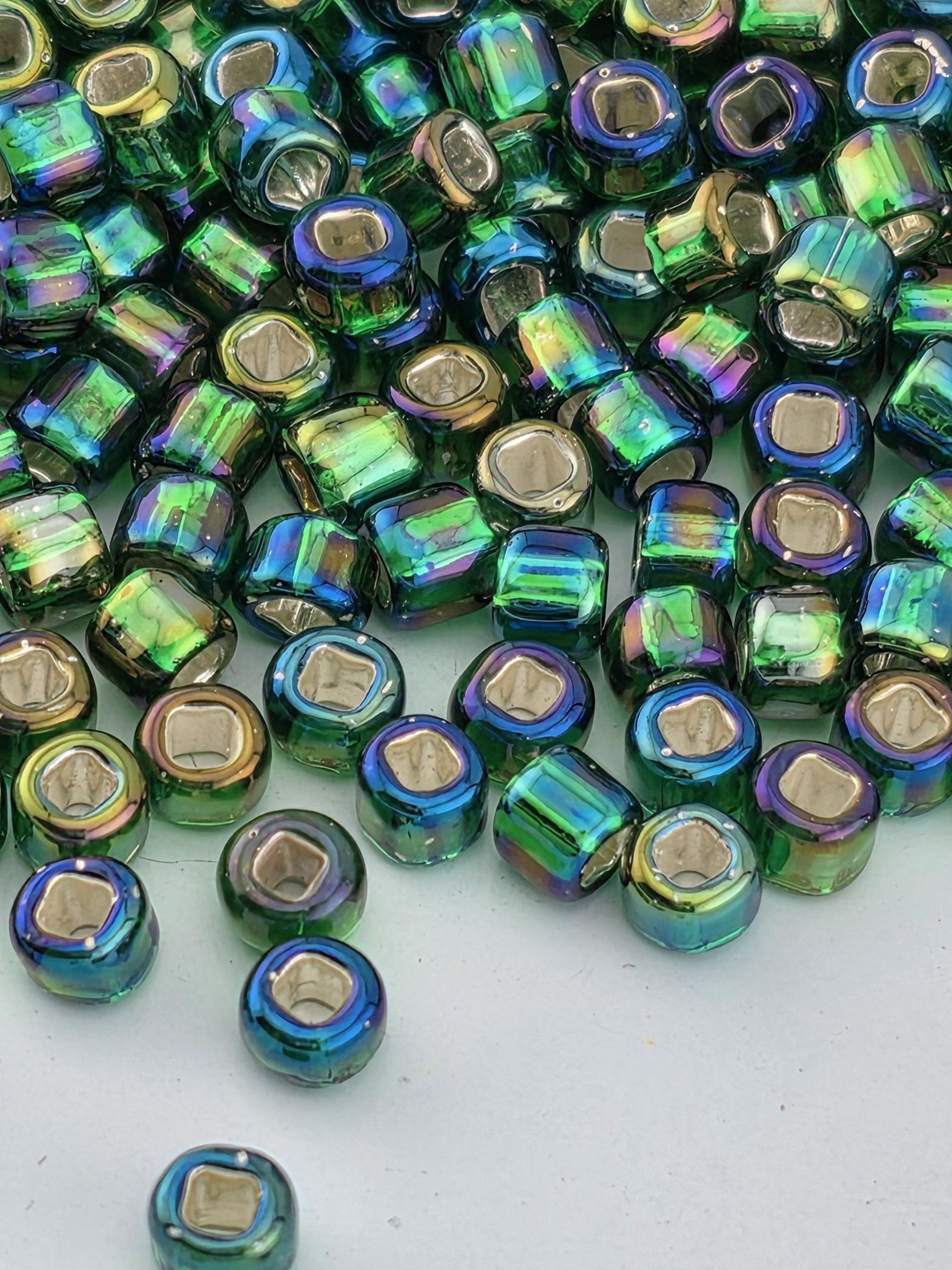 a collection of multicolored glass beads scattered on a white surface.