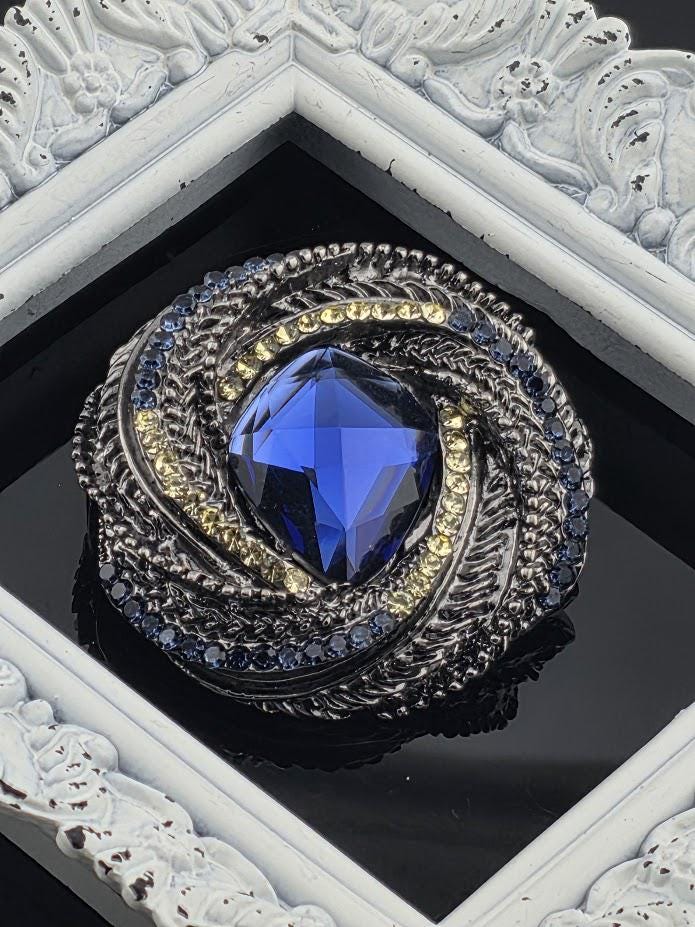 a large, blue gemstone set in a decorative metal frame.