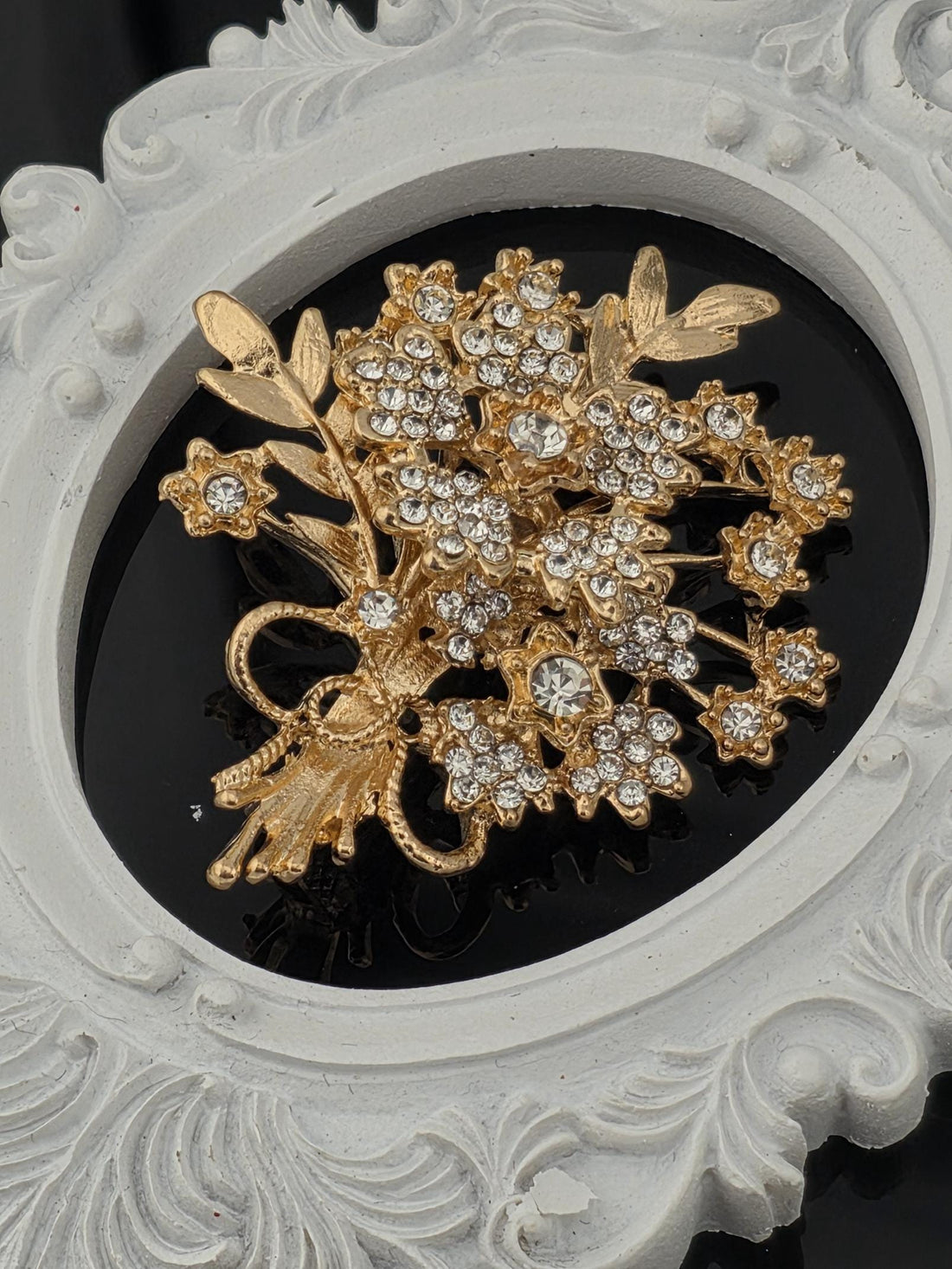 a decorative piece of jewelry with a floral design and sparkling gemstones.