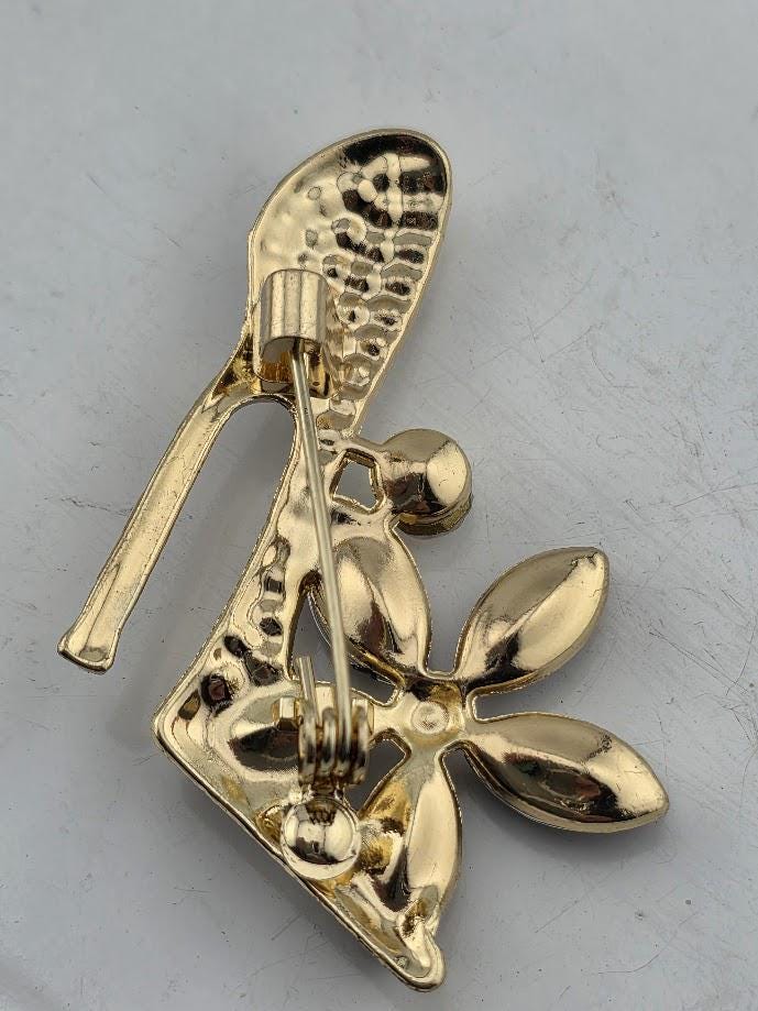 A close-up view of a decorative gold pin or brooch with a floral design.
