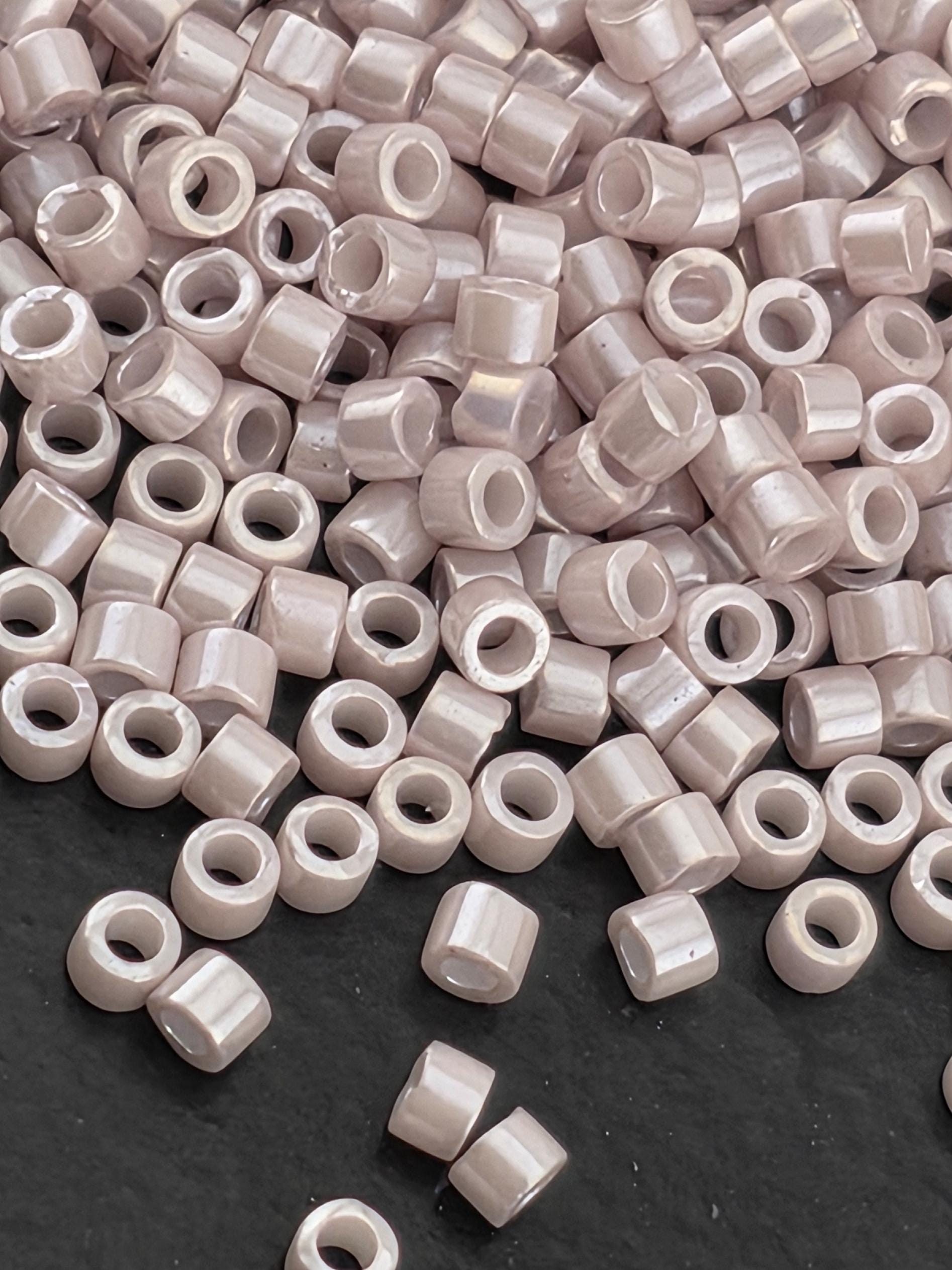 a close-up view of numerous small, round beads scattered on a dark surface.