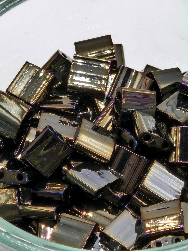 a close-up view of a pile of shiny, metallic beads or objects with a reflective surface, possibly made of glass or metal.