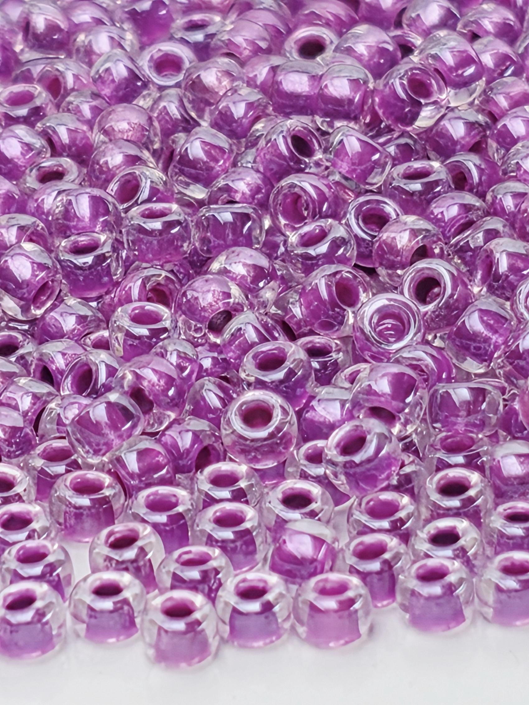 The image is a close-up of numerous clear, purple beads arranged in a visually appealing manner.