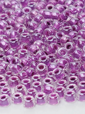 The image is a close-up of numerous clear, purple beads arranged in a visually appealing manner.