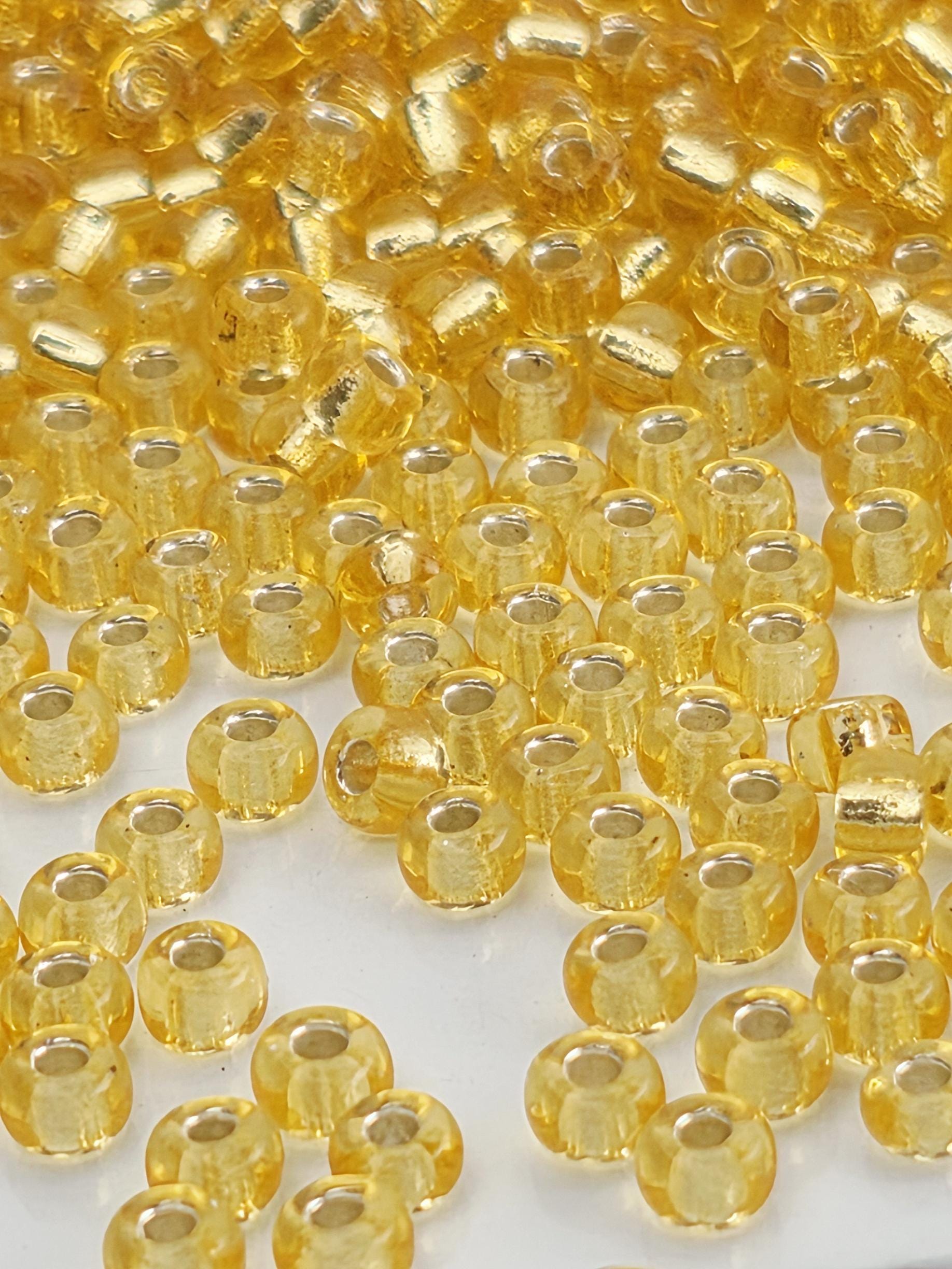 a close-up view of numerous small, round, yellow beads scattered across a surface.