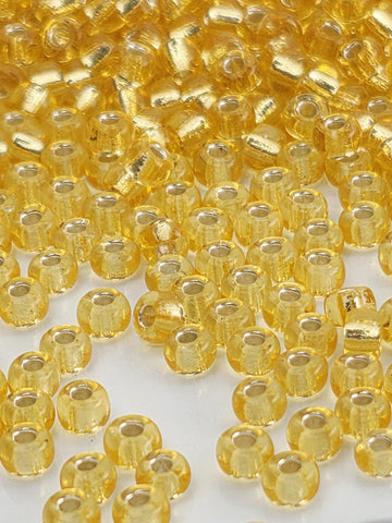 a close-up view of numerous small, round, yellow beads scattered across a surface.