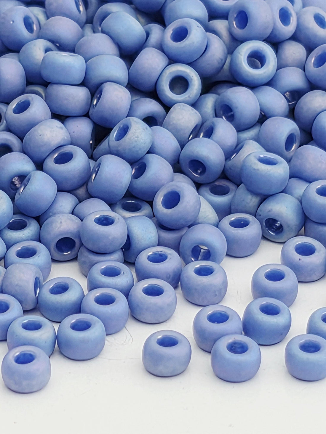 A close-up image of numerous blue beads or beads, likely made of glass or plastic, scattered and overlapping each other.