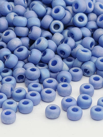 A close-up image of numerous blue beads or beads, likely made of glass or plastic, scattered and overlapping each other.