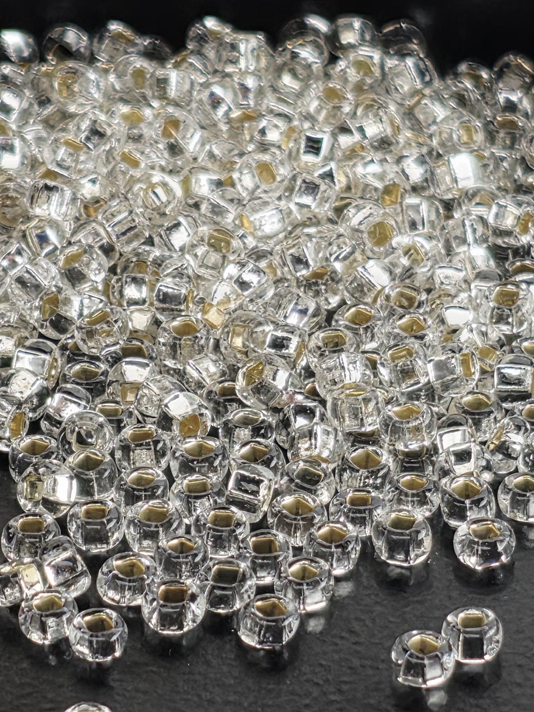 a close-up view of numerous clear glass beads scattered across a surface.