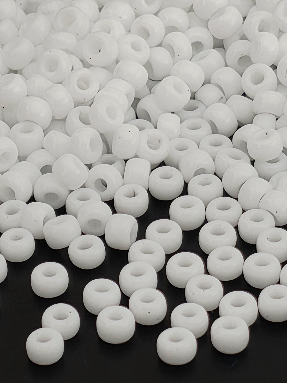 numerous white beads scattered across a dark background.