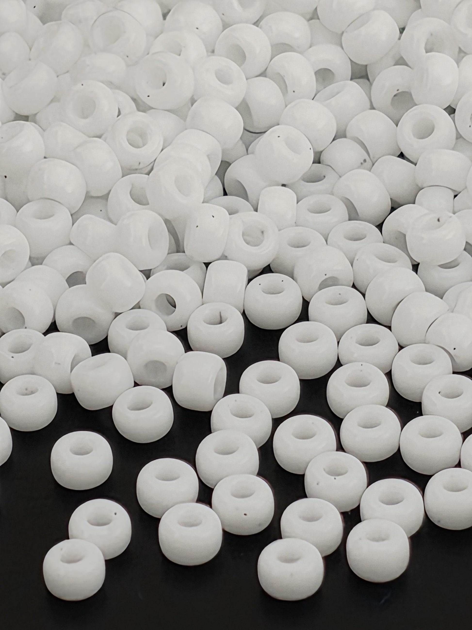 numerous white beads scattered across a dark background.