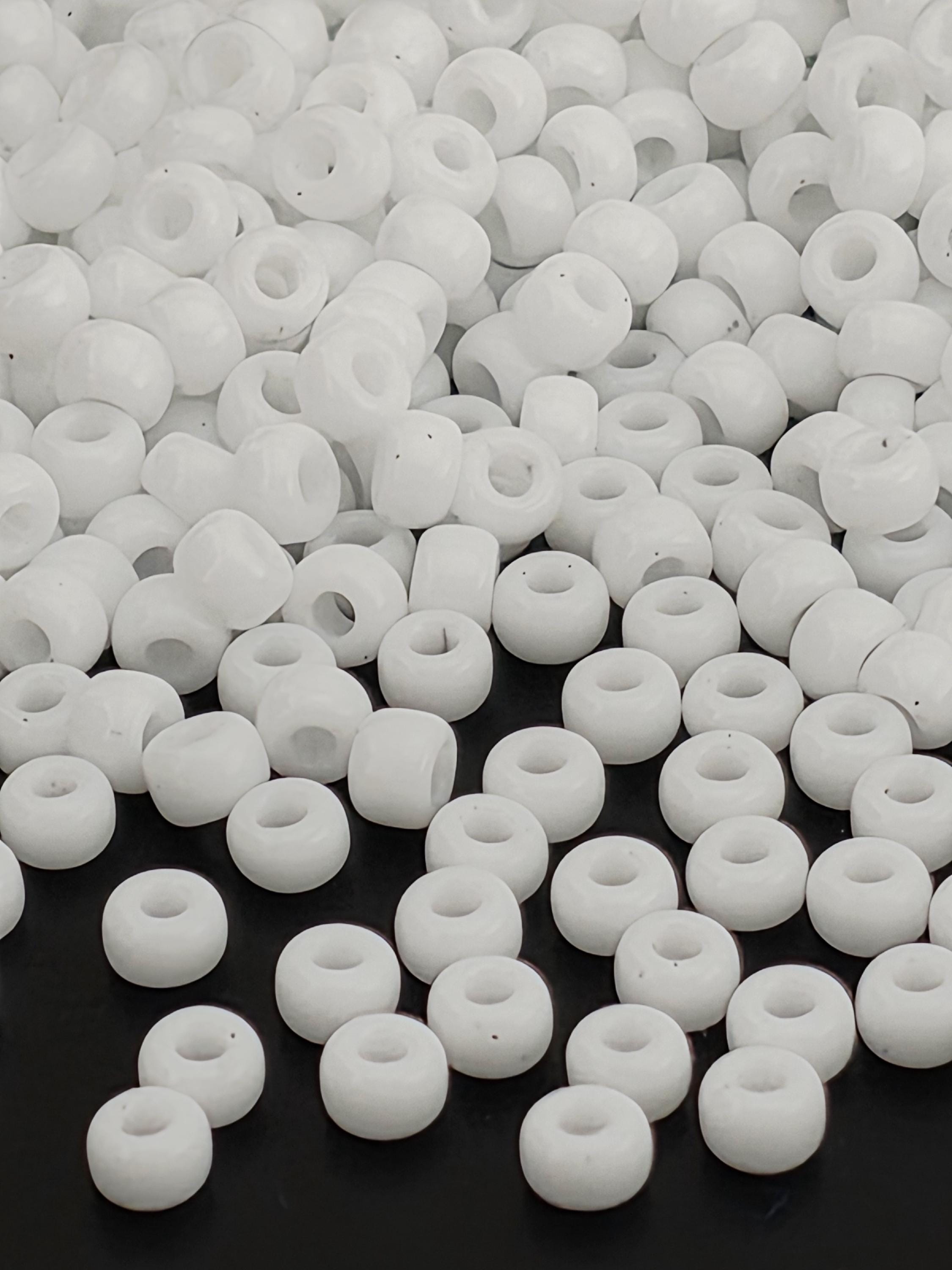 numerous white beads scattered across a dark background.
