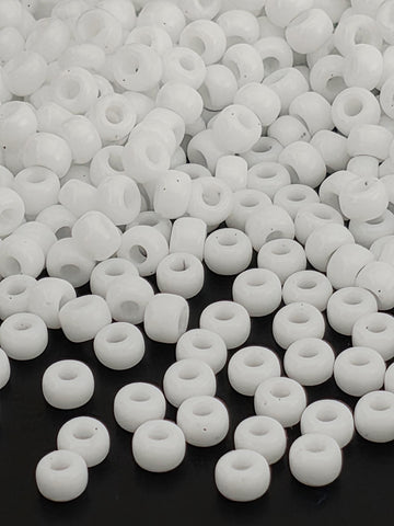 numerous white beads scattered across a dark background.