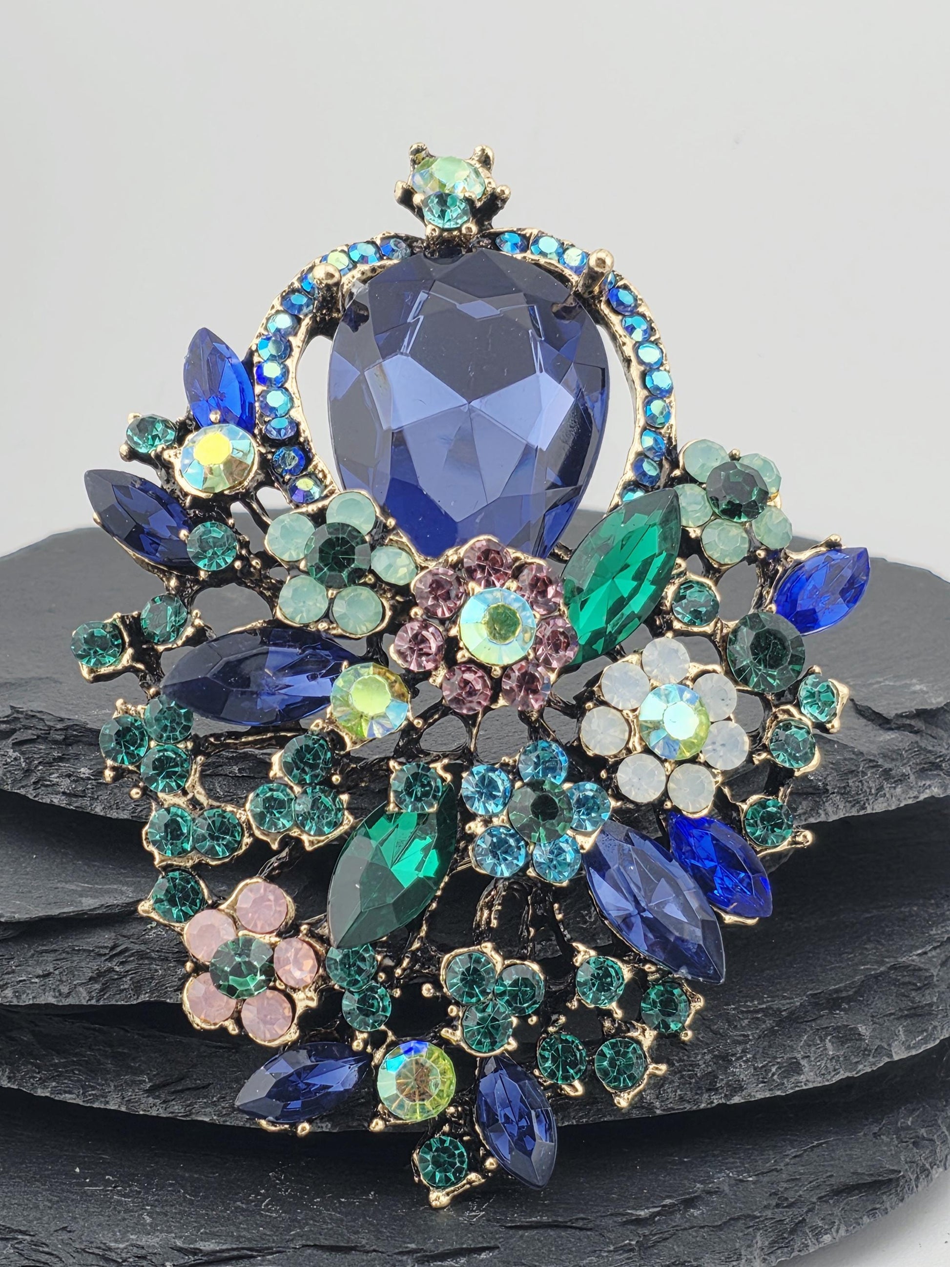 a decorative piece of jewelry with a variety of colorful gemstones and floral elements.