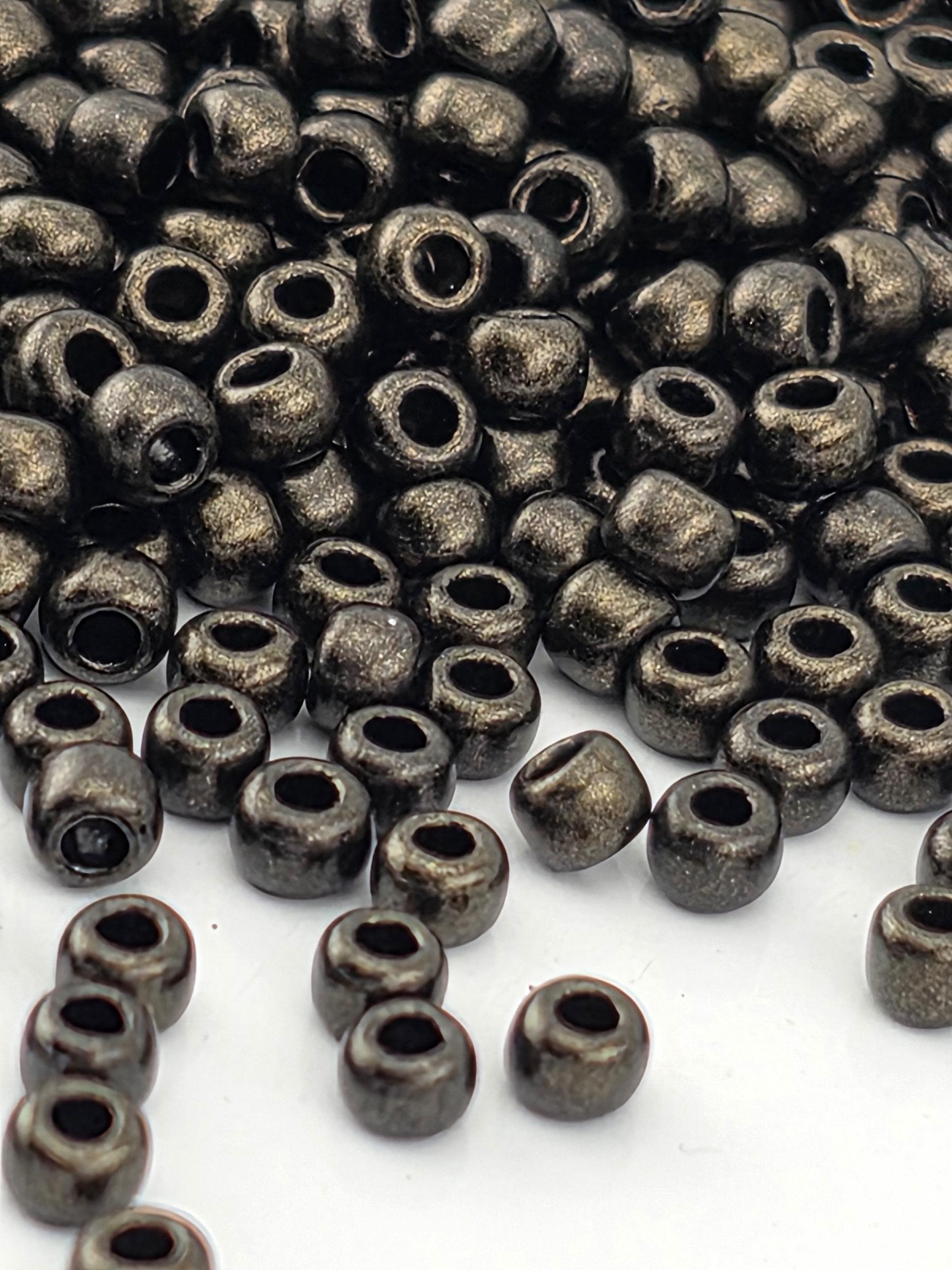 a close-up view of numerous small, shiny metal beads scattered across a white surface.