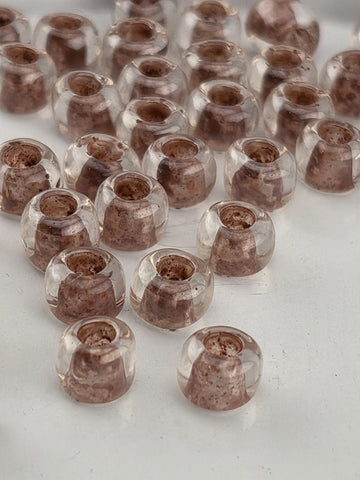 a collection of clear glass beads arranged in a pattern on a white surface.