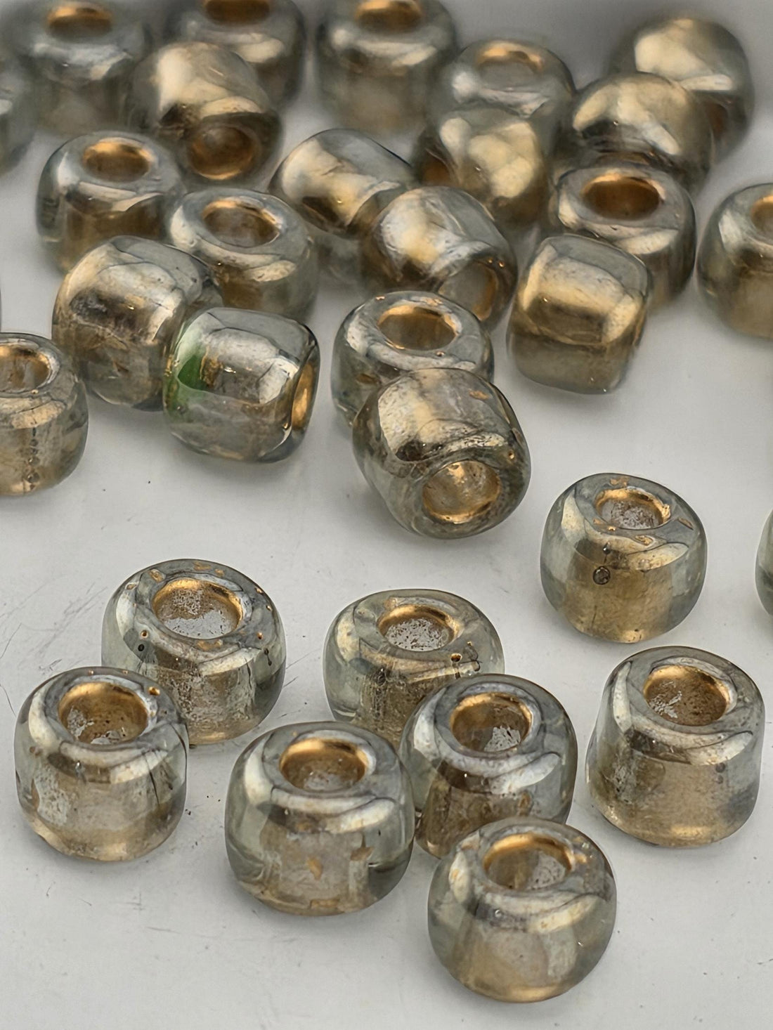 a collection of small, clear glass beads scattered on a white surface.