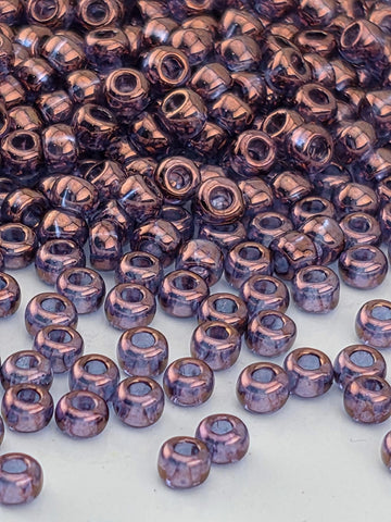 a close-up view of numerous small, round beads in shades of purple, scattered across a surface.