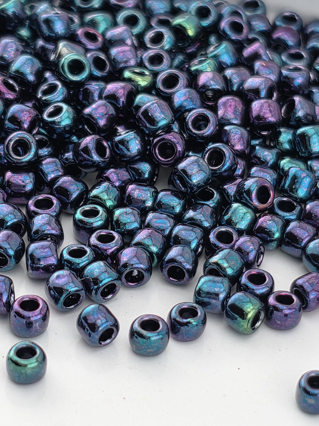 A pile of multicolored glass beads in various shades of blue, purple, and green.