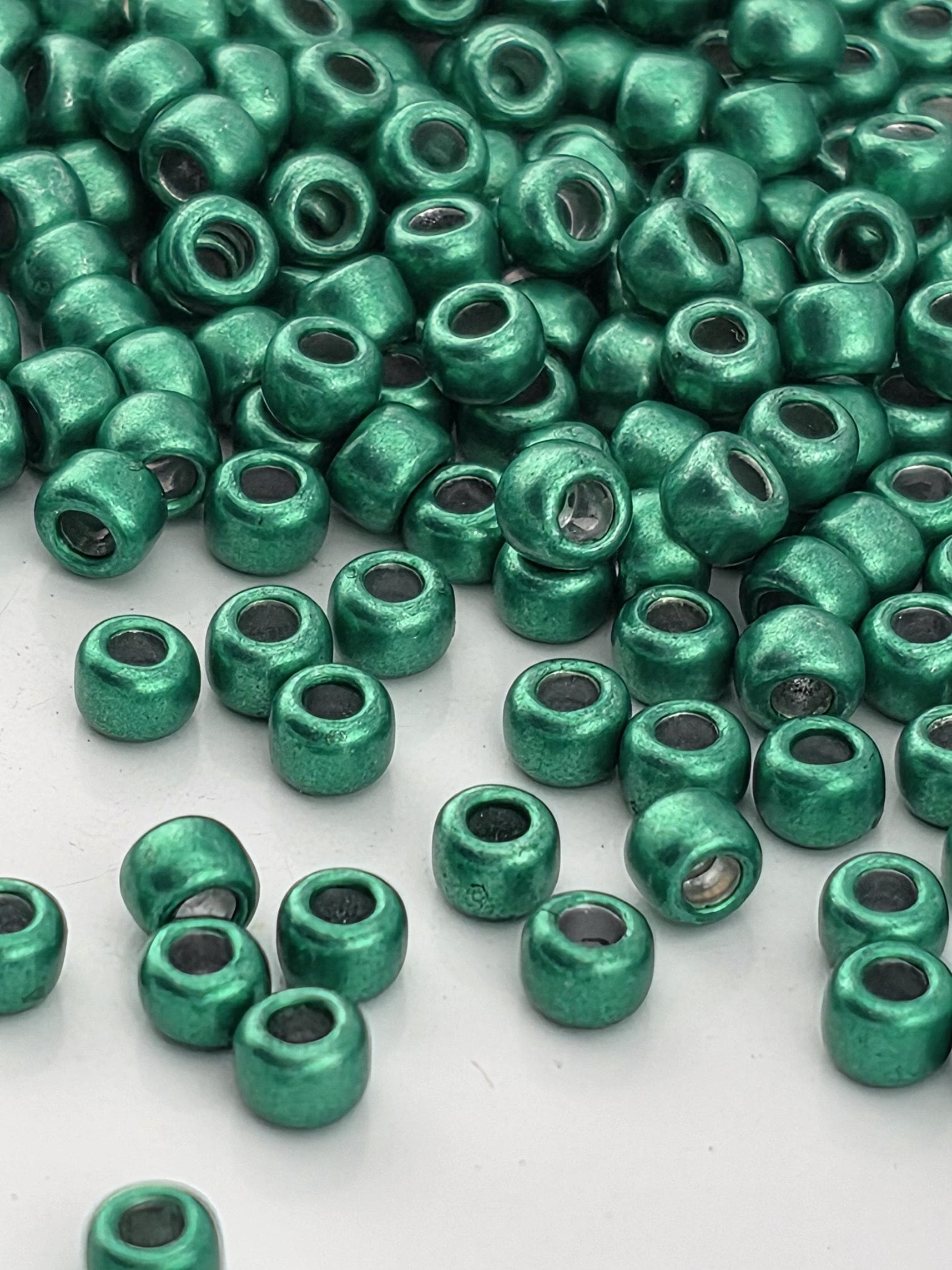 a collection of green beads scattered across a white surface.