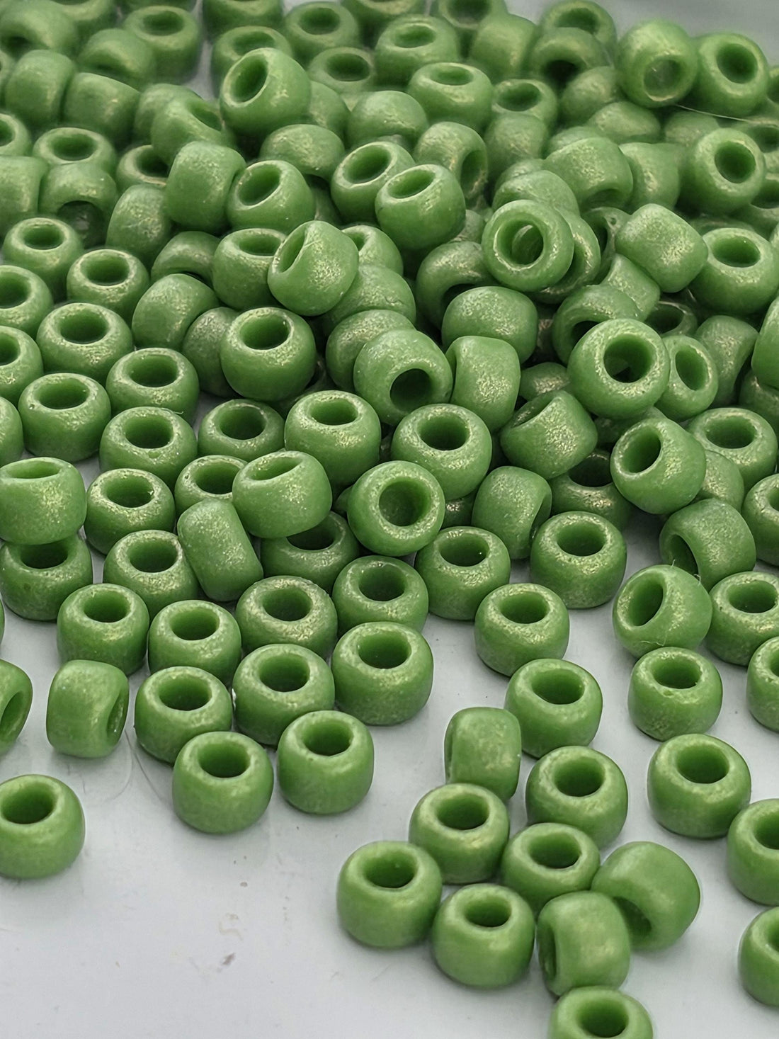 A pile of green beads or beads scattered on a surface.