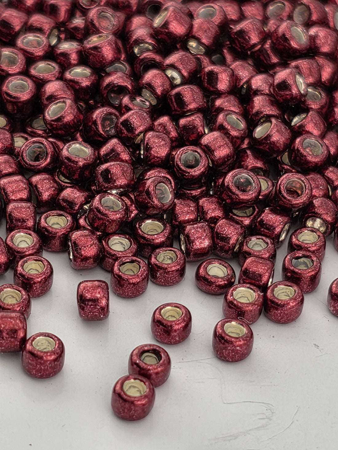 a close-up view of numerous red beads scattered across a white surface.