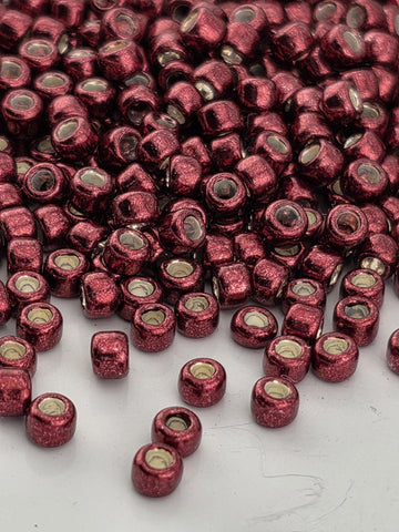 a close-up view of numerous red beads scattered across a white surface.